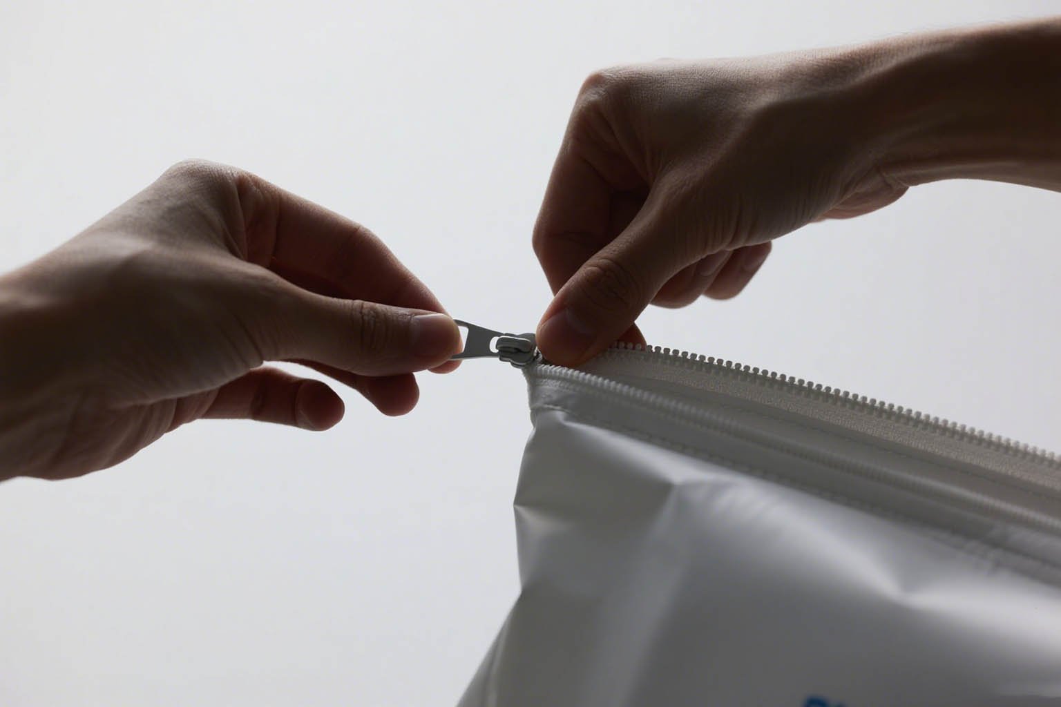A person inspecting the stitching and zipper on a high-quality rPET cooler bag