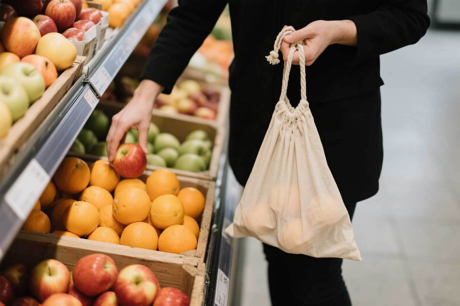una persona che utilizza una borsa di mussola per fare la spesa