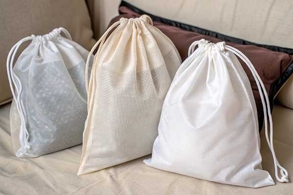 A display showing non-woven, cotton, and plastic bags side-by-side