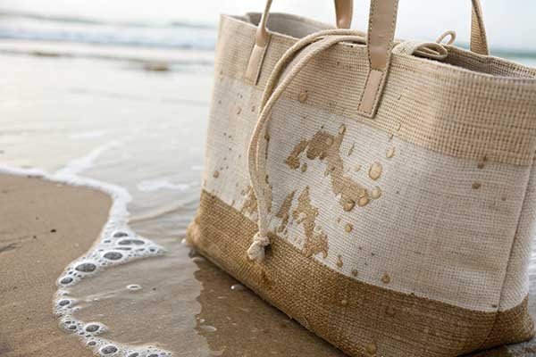 An illustration of a jute bag with a small water droplet on it, and a darker area where the water is absorbed into the material
