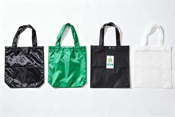 Four reusable bags of different materials are shown from left to right: polyester, nylon, rpet, and non - woven.