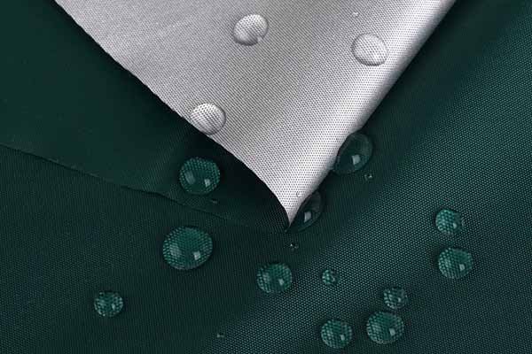 A close - up of Oxford cloth showcasing its waterproof property, with water droplets beading up on the fabric's surface.
