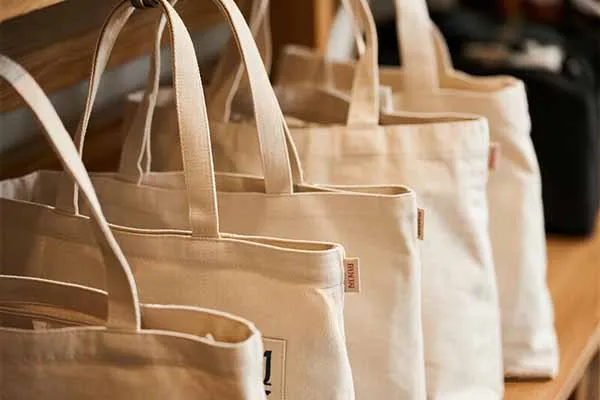Multiple canvas bags with woven labels on the sides