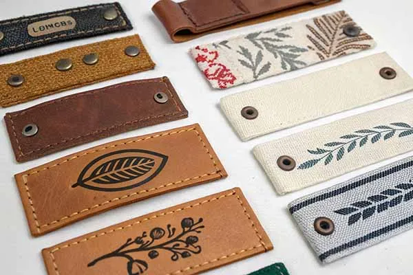 A collection of decorative labels made from leather and fabric, featuring various designs and patterns.