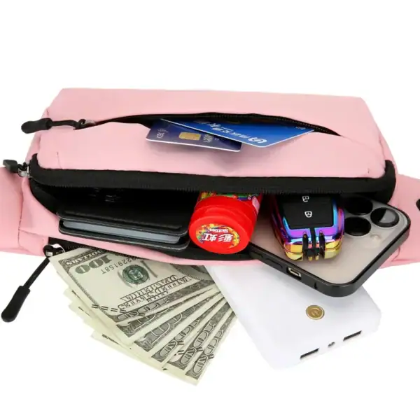 A pink travel bag containing essentials such as a credit card, cash, a mobile phone, a power bank, a car key, and a small bottle is opened to reveal its contents.