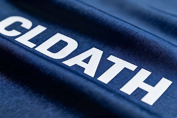 A close-up of a screen-printed logo on a thick polyester fabric, showing clear lines.