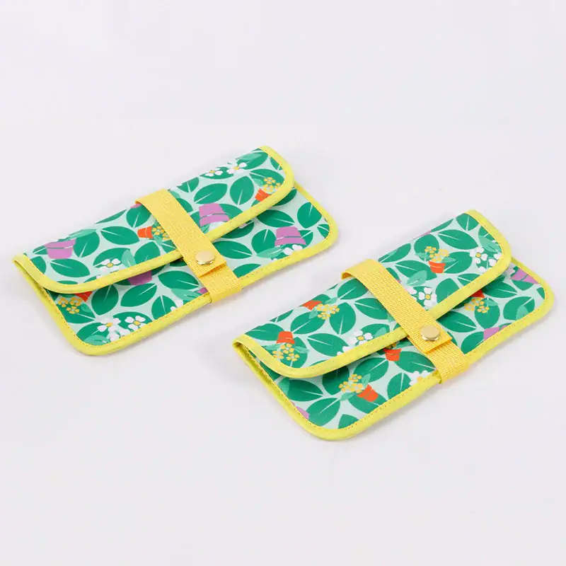 Two colorful flower pattern wallets with yellow straps and green leaves design.