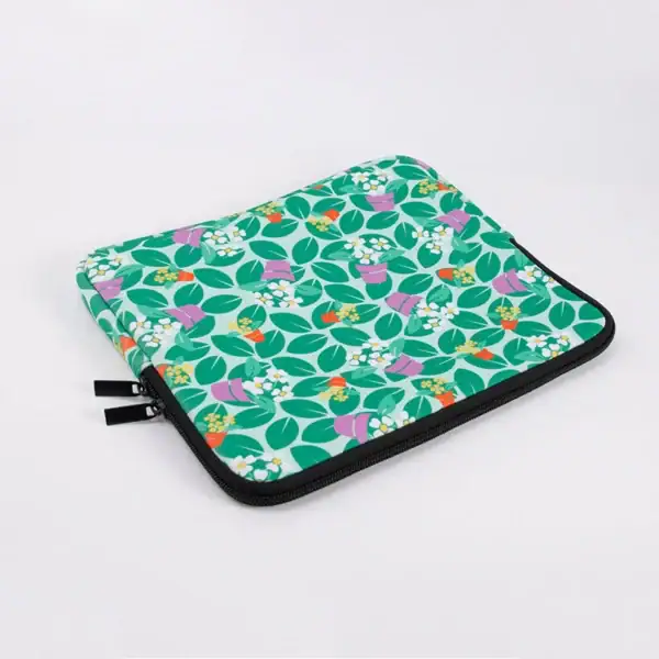 A green laptop sleeve featuring a floral pattern with pink, orange, and white flowers and leaves.