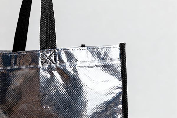 Close - up of a laminated bag, showing the laminated surface and stitching details clearly.