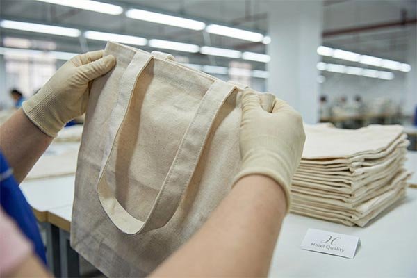 Worker sewing bags in factory