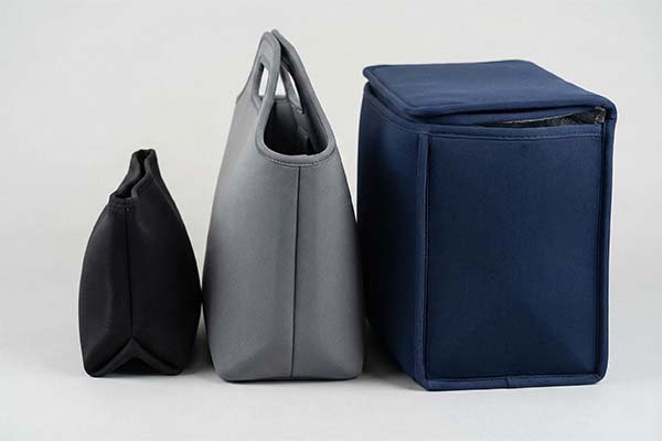 three neoprene bags of varying sizes and colors.