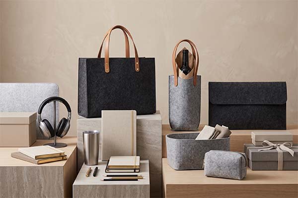 Premium custom dark grey felt tote bags, laptop sleeves, and wine carriers featuring brown leather handles