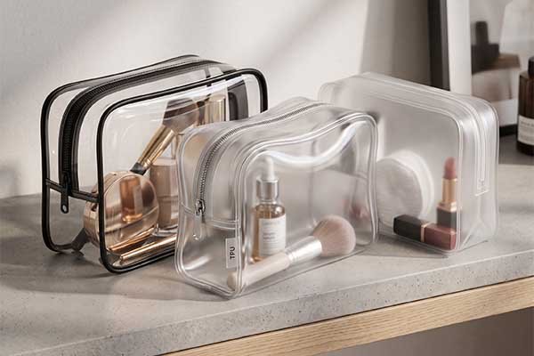 Custom semi-transparent frosted and clear TPU cosmetic bags with zipper closures, designed for B2B beauty brand packaging and retail display.